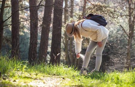 picture of woman spraying bug spray